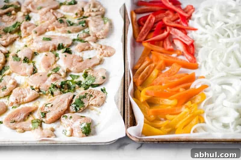 Zesty Mexican Citrus Marinade for Juicy Chicken 5 Chicken fajitas on two sheet pans, one with chicken, the other with bell peppers and onion.