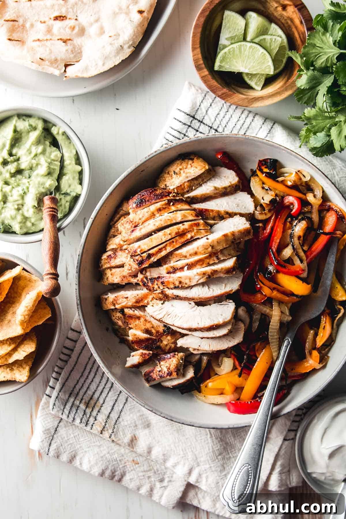 Zesty Mexican Citrus Marinade for Juicy Chicken 6 Sliced mexican citrus chicken in a bowl with fajita peppers and onions.
