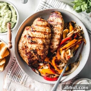 Zesty Mexican Citrus Marinade for Juicy Chicken 7 Mexican citrus marinated chicken breasts in a bowl with grilled bell peppers and onions.