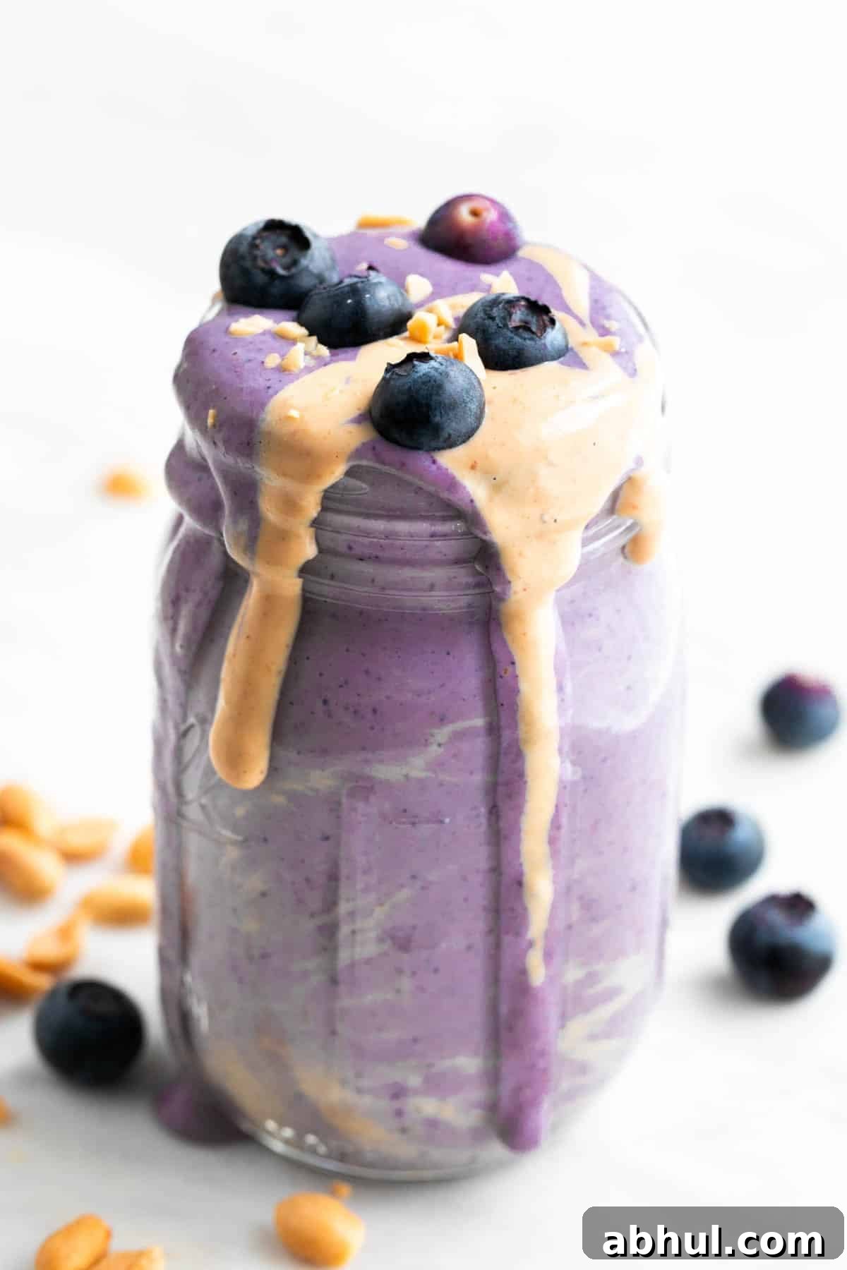 Silken tofu smoothie in a jar with toppings and ingredients arranged around it.