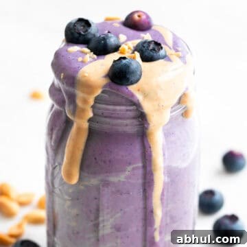 Silken tofu smoothie in a jar with toppings and ingredients arranged around it.