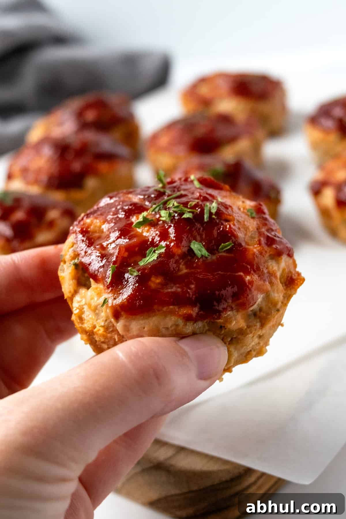 A hand holding a turkey meatloaf muffin.