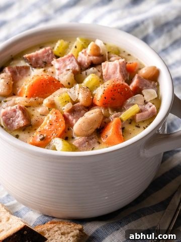 ham and white bean chowder in white bowl with bread