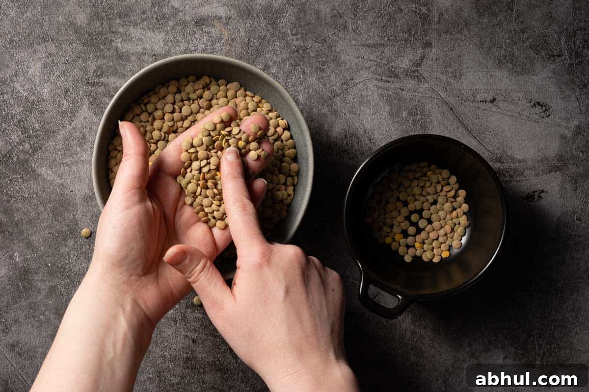 hand holding dried lentils over two bowls