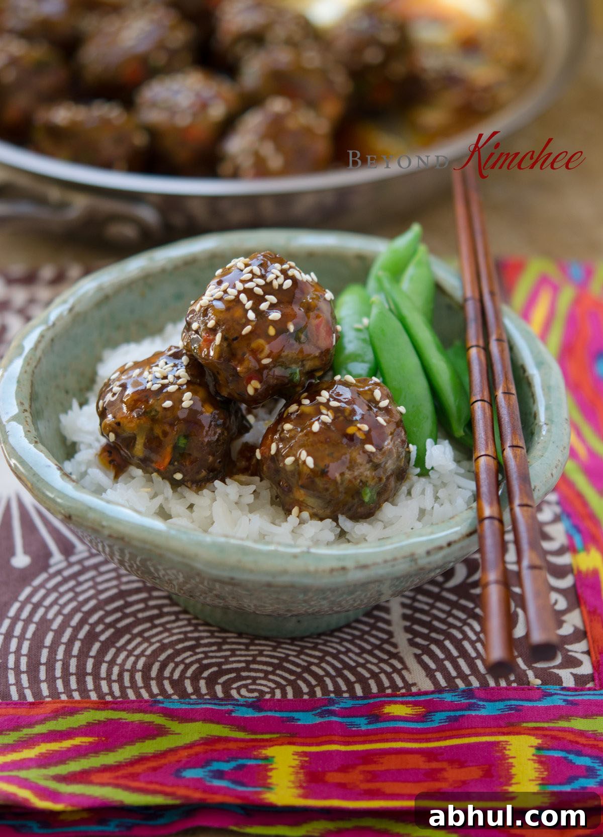 Glazed Asian meatballs served with rice and fresh snow peas