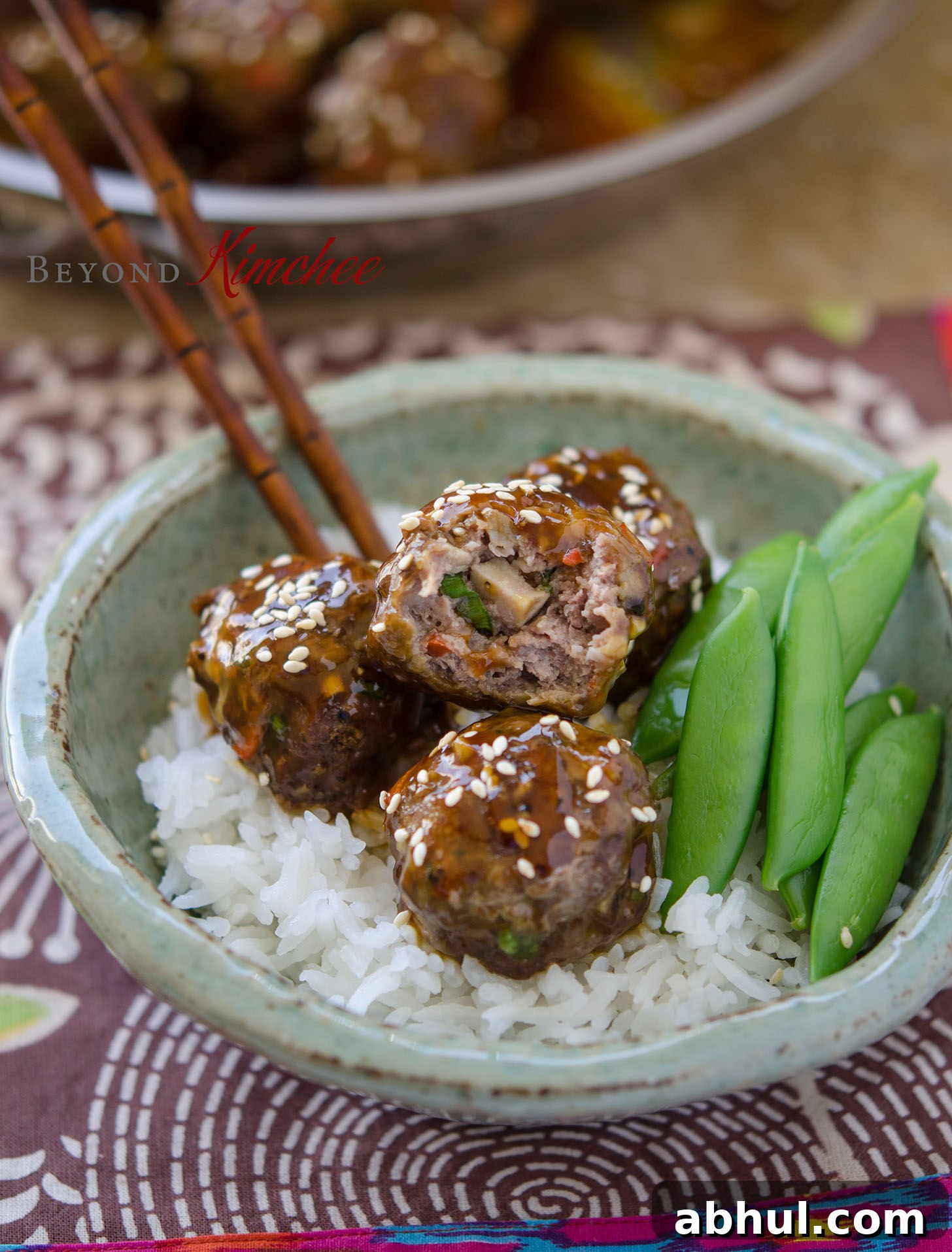 Beef meatballs with rice and snow peas.