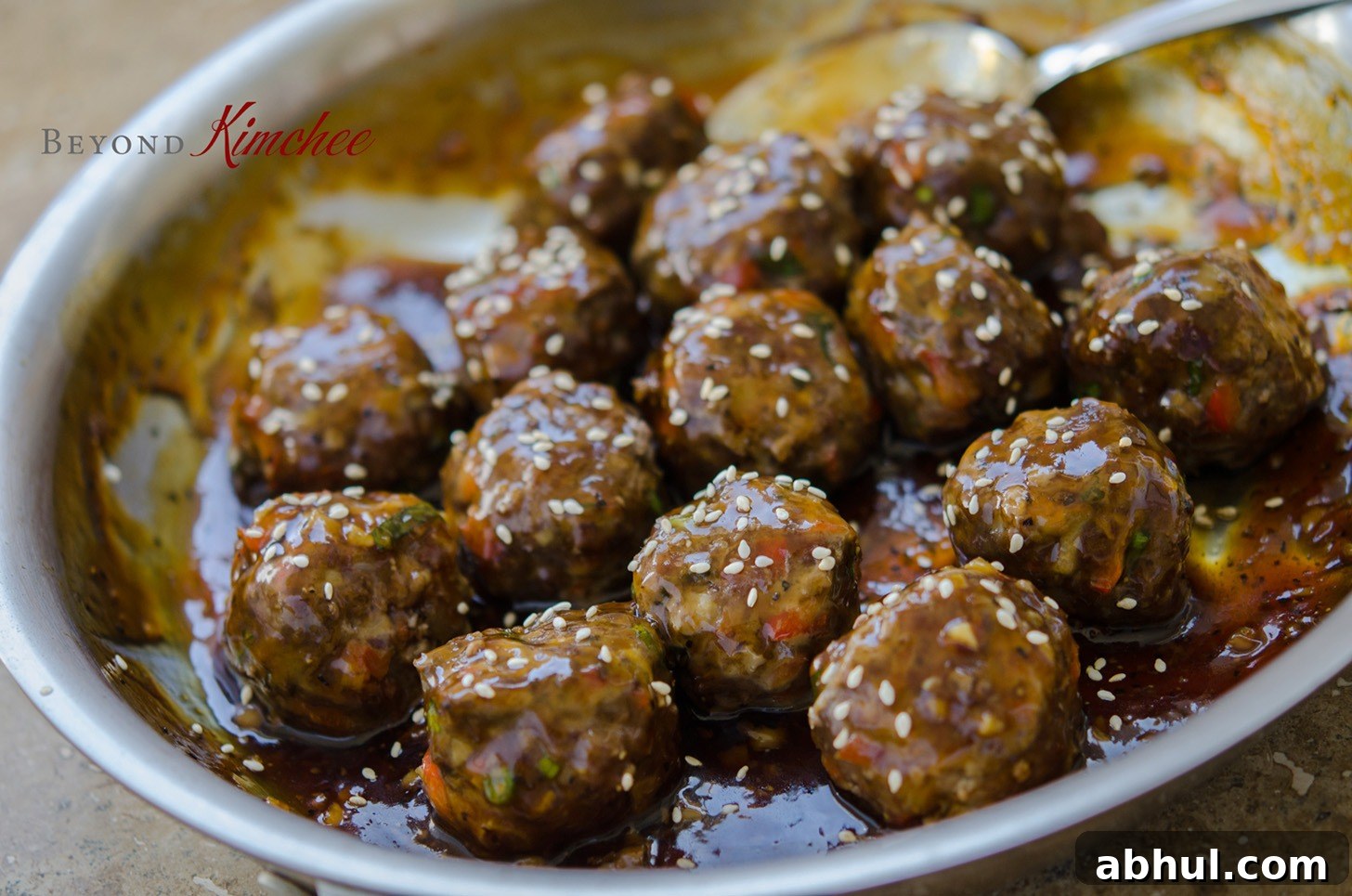 Sweet and savory meatballs coated in pineapple soy glaze in a pan