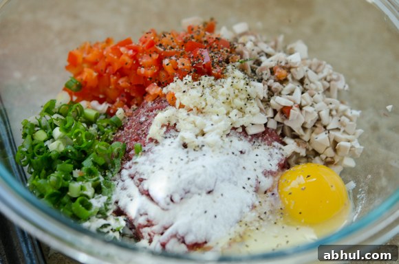 Ground beef mixture with vegetables and seasonings in a mixing bowl
