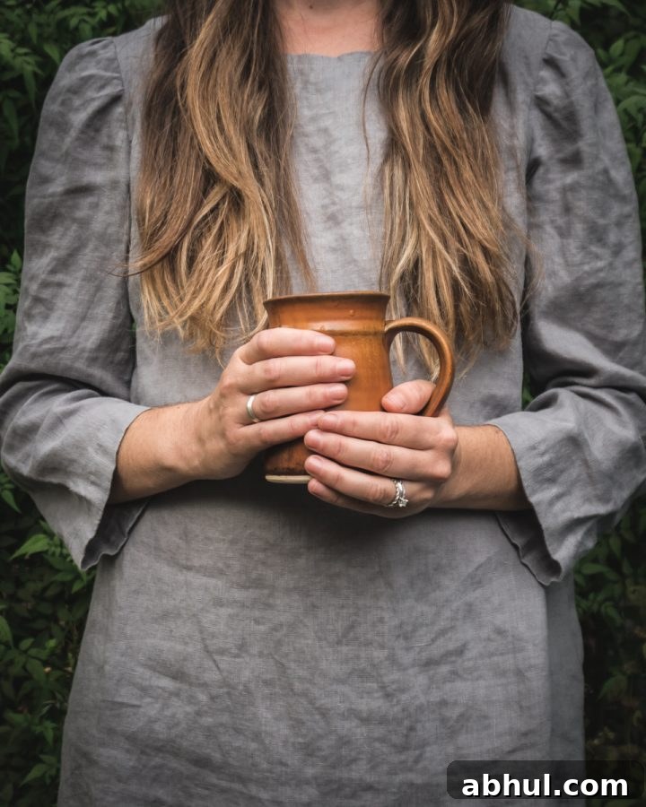 woman holding a brown coffee mug full of homemade bone broth