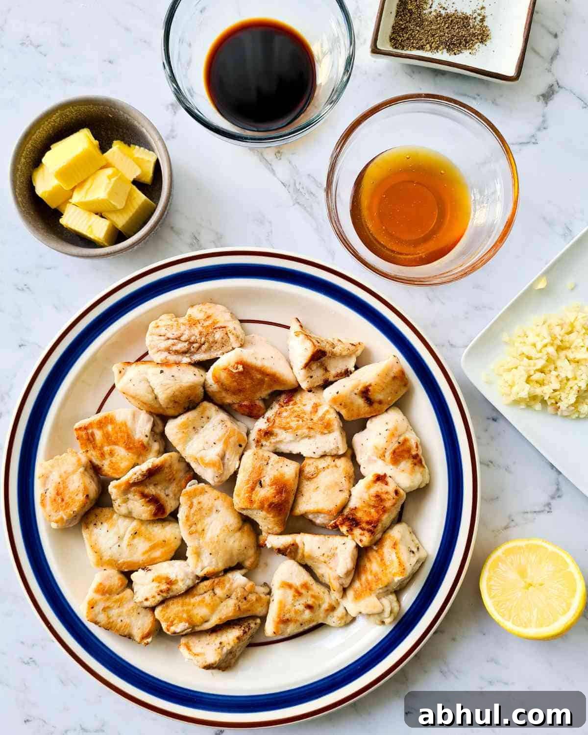 A plate of golden browned chicken pieces surrounded by glaze ingredients
