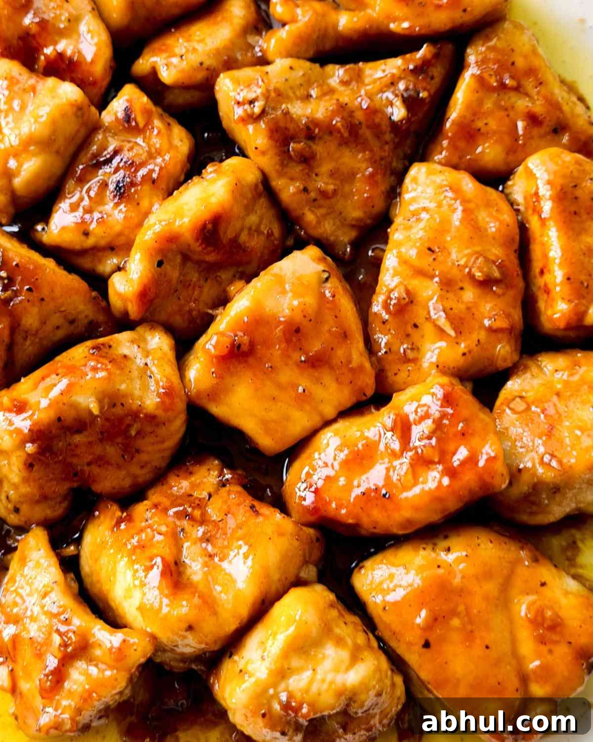 Close up of glossy glazed chicken bite sized pieces