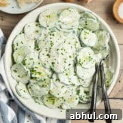 This is a square picture of a bowl of creamy French cucumber salad.
