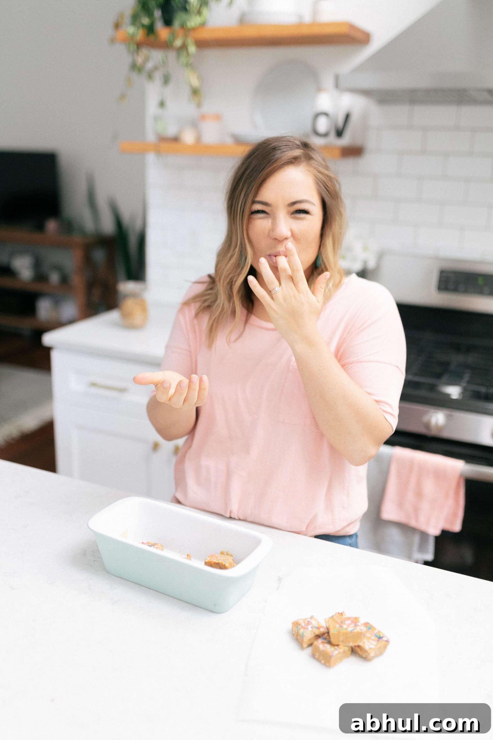 molly thompson standing at and island eating anti inflammatory keto fudge