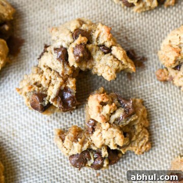 peanut butter chocolate chip cookie torn apart on a baking sheet.