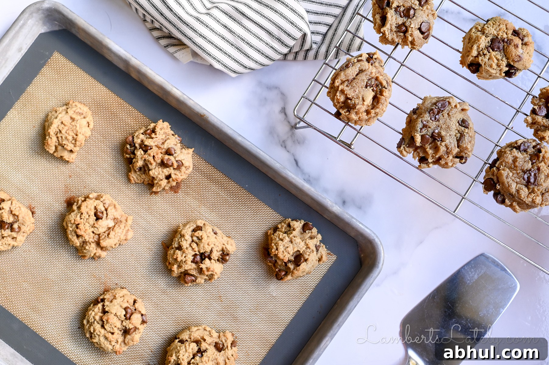peanut butter chocolate chip cookies cooling on a baking rack, on a lined cookie sheet.