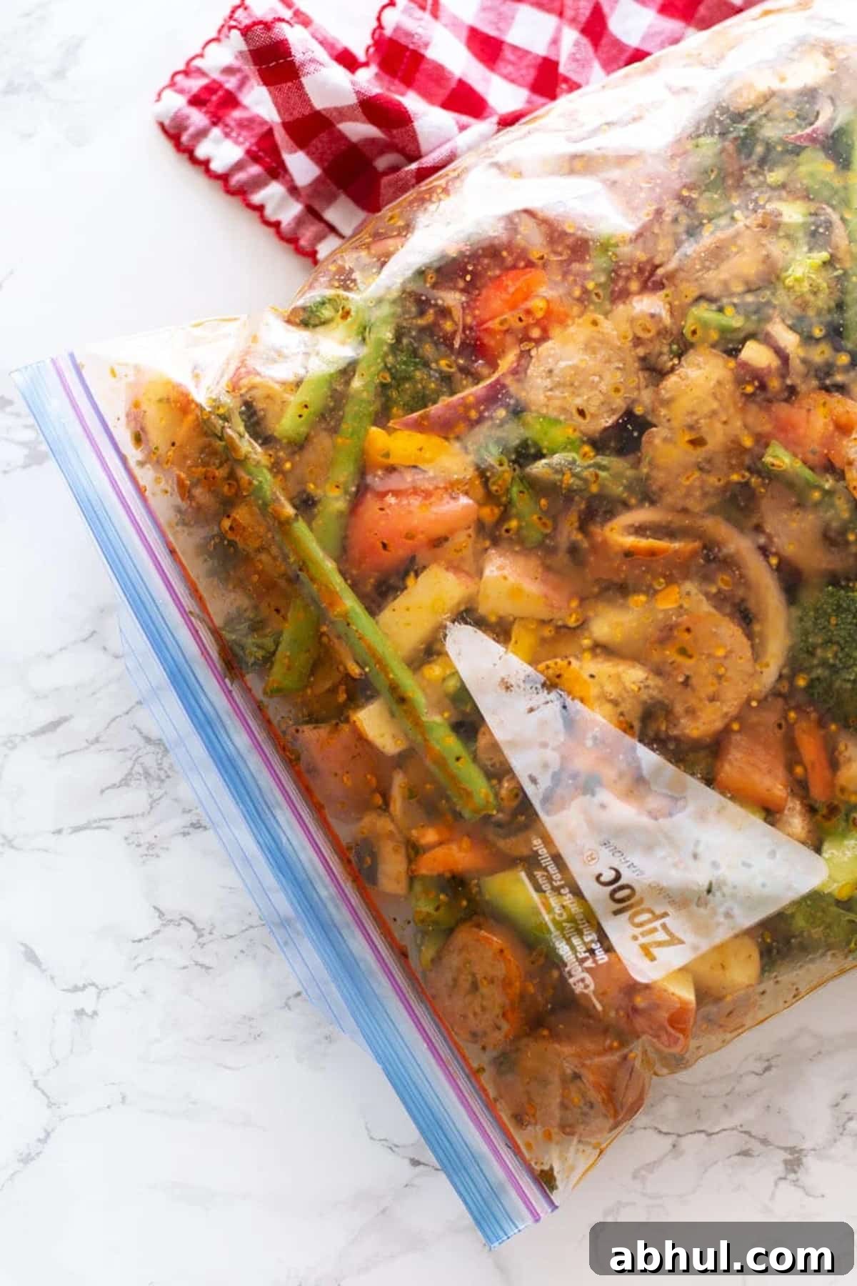Sheet Pan Sausage with Roasted Vegetables Recipe 7 Ziplock bag with sausage and vegetables in lemon herb marinade.