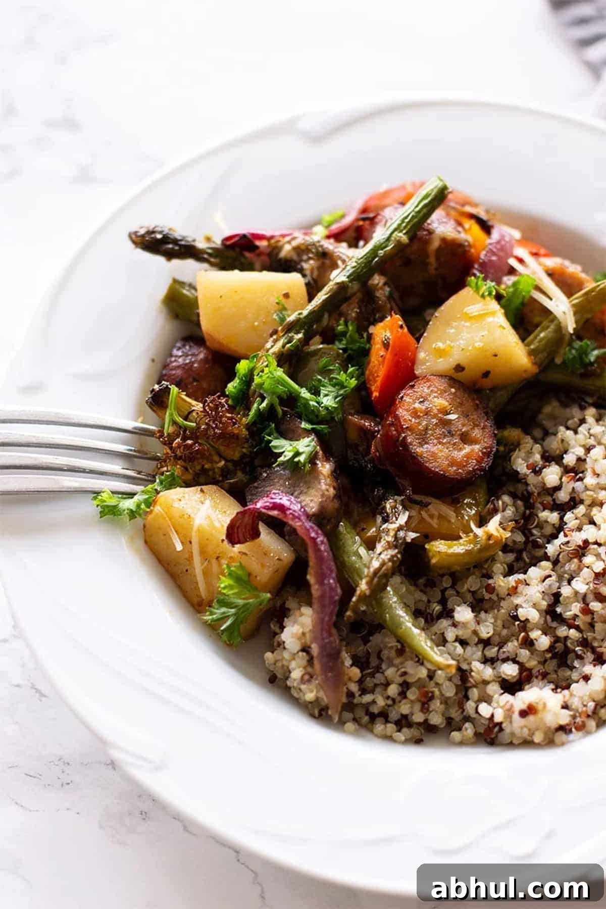 Sheet Pan Sausage with Roasted Vegetables Recipe 9 Bowl of sausage and vegetables served with quinoa.