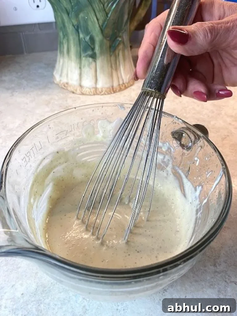 whisking up a batch of Alabama White Barbecue Sauce