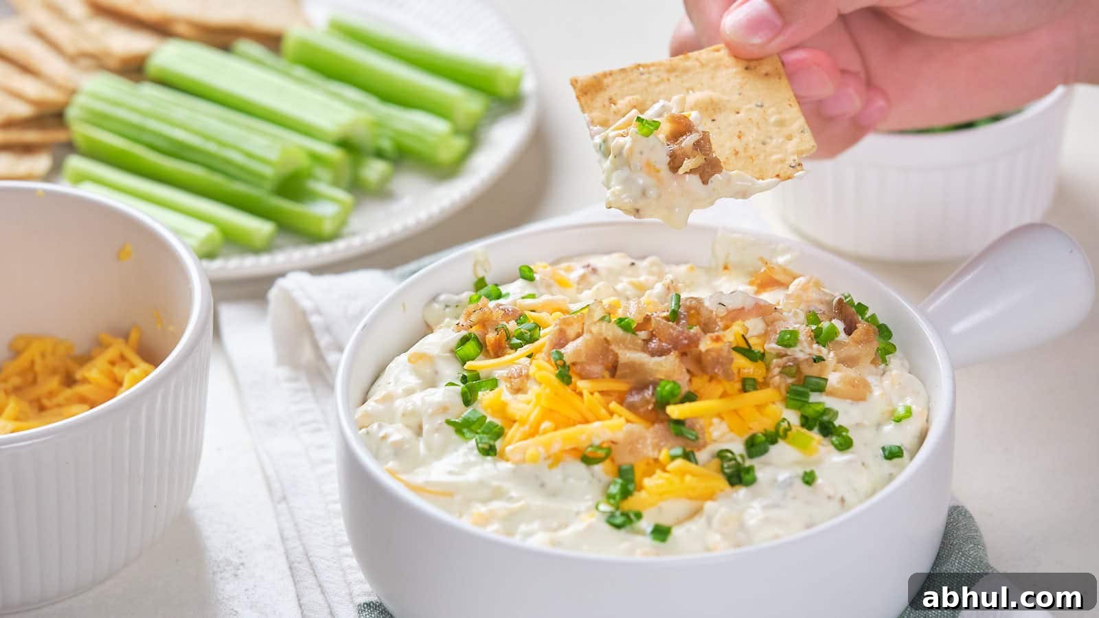 Bacon cheddar dip with shredded cheddar cheese, bacon bits, and chive garnish.