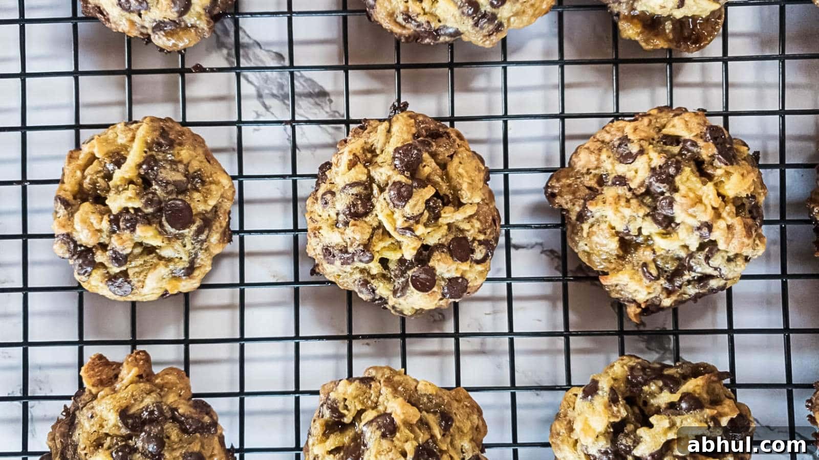 Keto magic cookies cooling on a black wire rack over a marble surface.