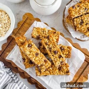 Chewy Einkorn Granola Bars with oats and chocolate chips on a wooden board.