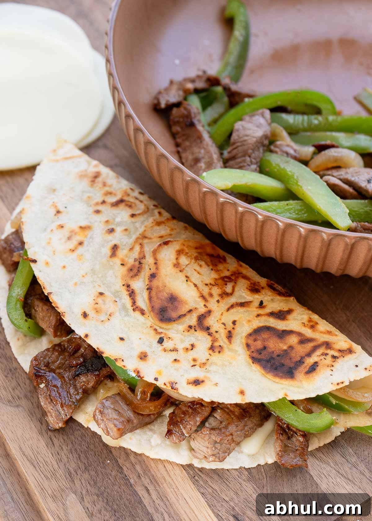 Philly Cheesesteak Wrap Recipe: Quick Steak & Cheese Wraps 3 juicy steak, onions, and peppers in a fried quesadilla