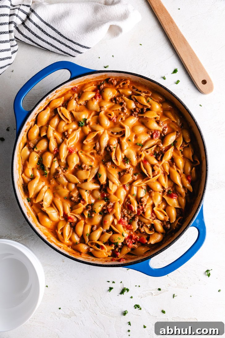 Skillet filled with cheesy pasta and ground beef.
