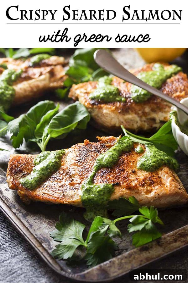 A simple pan searing in a cast iron pan gives my salmon with green sauce golden brown crispy skin worthy of a restaurant dinner! Add in an easy and vibrant sauce full of basil and parsley and you have a delicious and healthy weeknight meal. | justalittlebitofbacon.com #salmonrecipes #fishrecipes #glutenfreerecipes #dinnerrecipes #salmon
