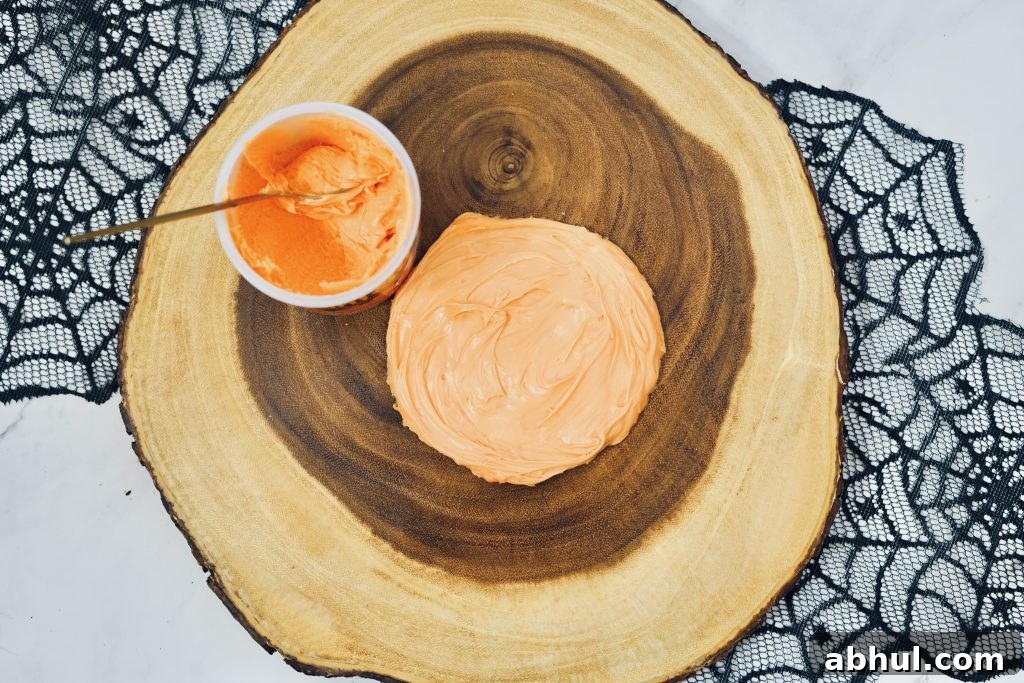 Forming pumpkin with orange frosting