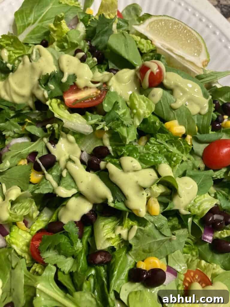 A chopped salad with corn, black beans, tomatoes and avocado dressing.