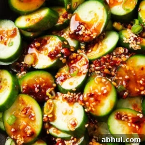 Overhead photos of scallions, sesame, chili, and soy sauce top Asian Cucumber Salad.