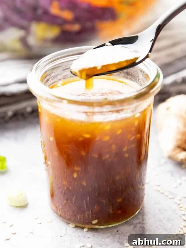 Jar of asian salad dressing with sesame seeds floating in it