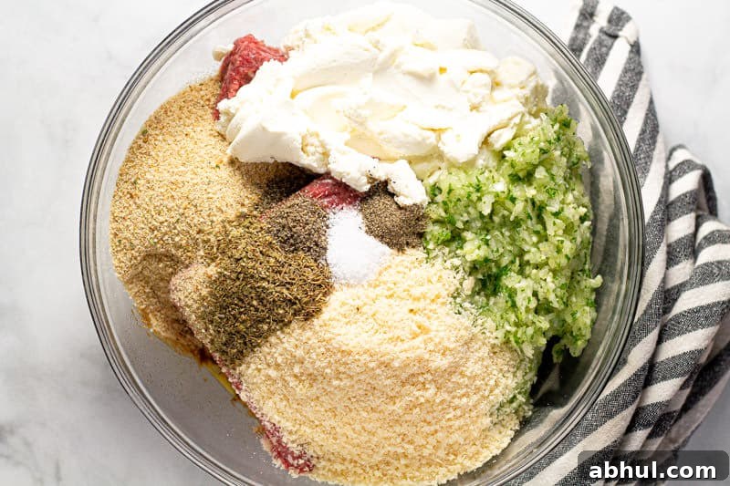 Large glass bowl filled with ingredients to make meatloaf