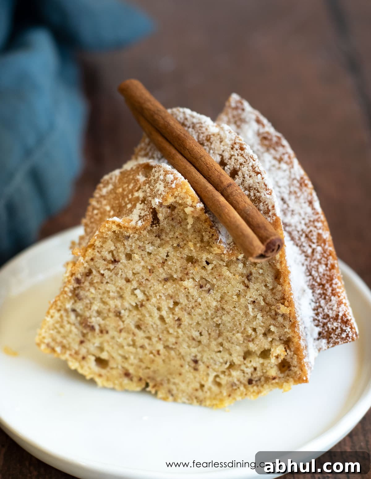A slice of gluten free eggnog bundt cake on a white plate.