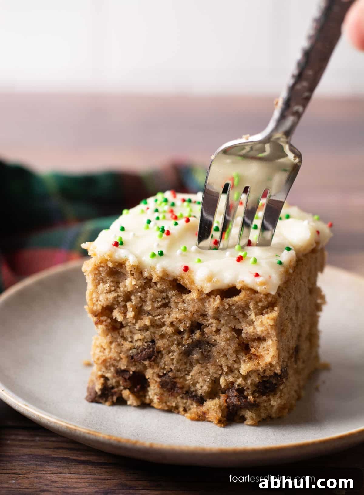 Pushing a fork into a slice of cake to get a bite.