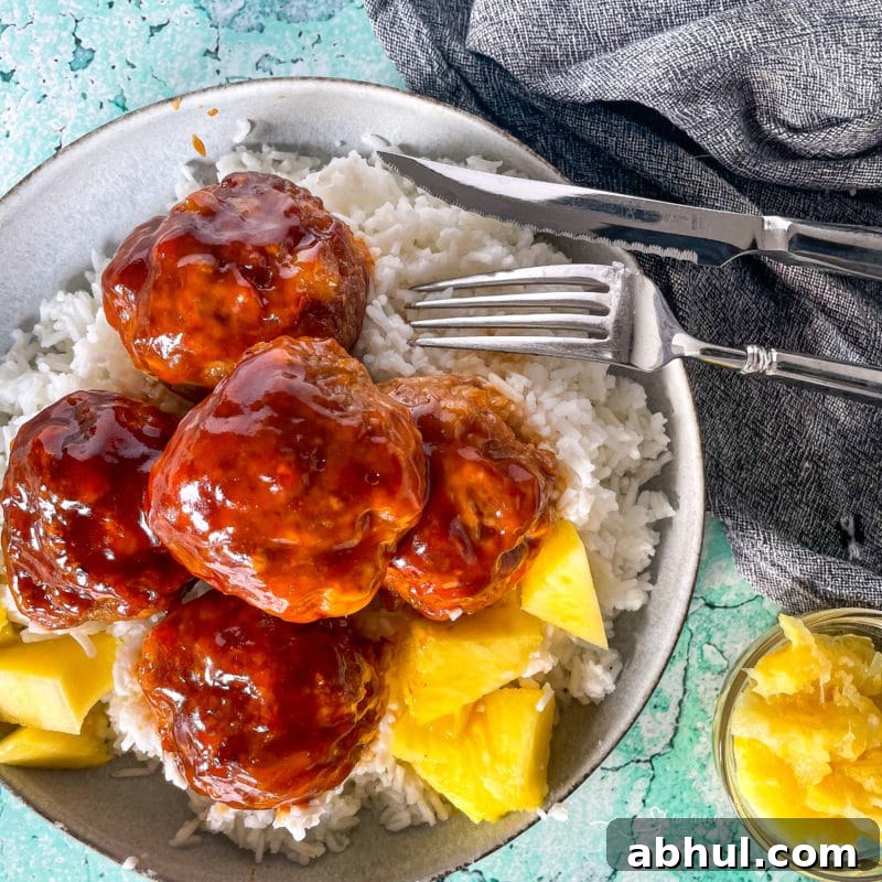 Top view of Hawaiian ham balls in bowl with pineapple chunks and rice