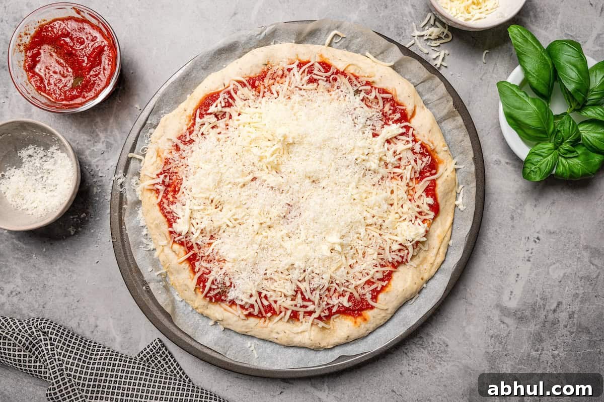 Shredded mozzarella and Parmesan cheese added on top of pizza sauce on a cottage cheese pizza crust.