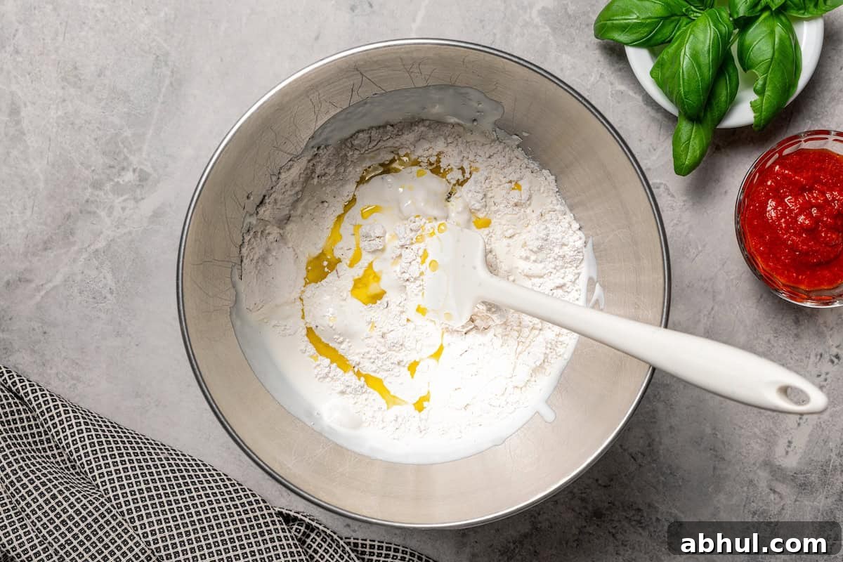 Olive oil and flour added to blended cottage cheese in a bowl.