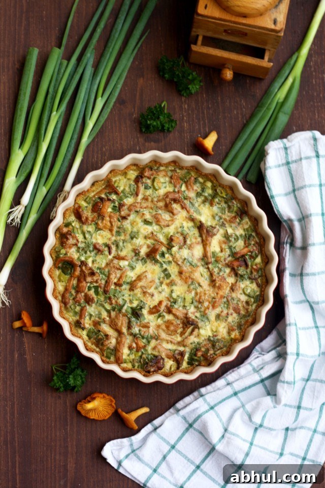 Mushroom quiche with quinoa pie crust in a baking dish with scallions