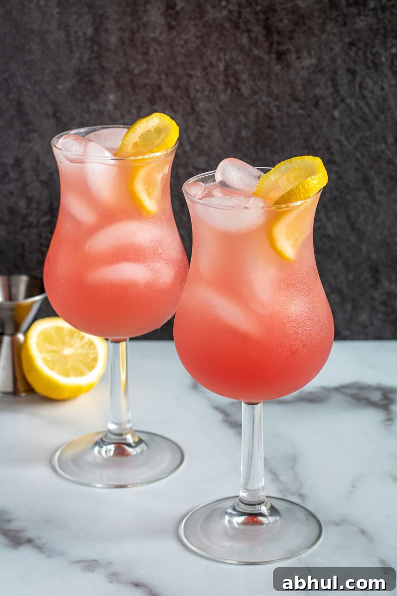 Cranberry grapefruit fizz cocktail in two glasses with lemon