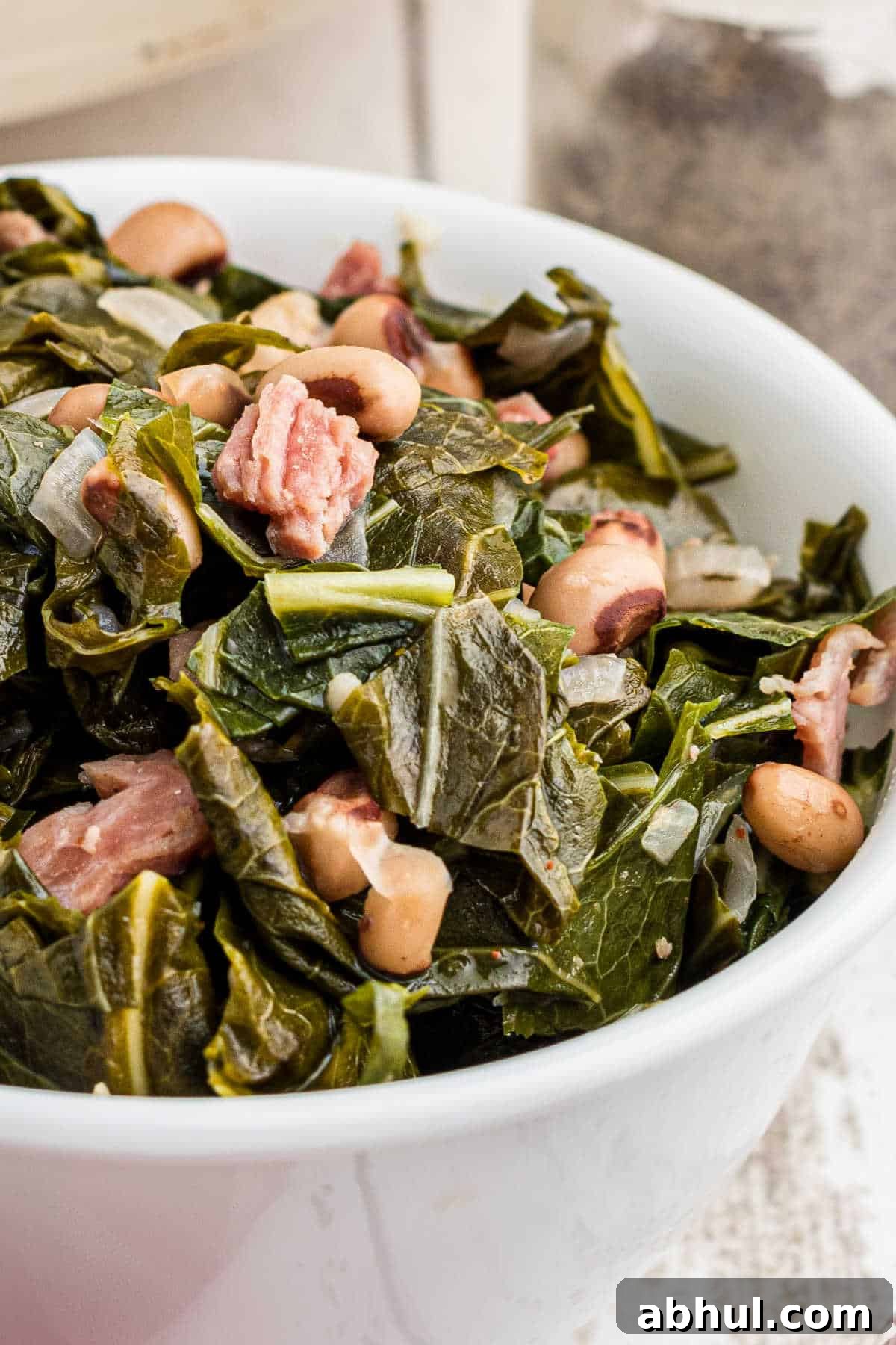 Close up of a bowl of collard greens with black eyed peas.