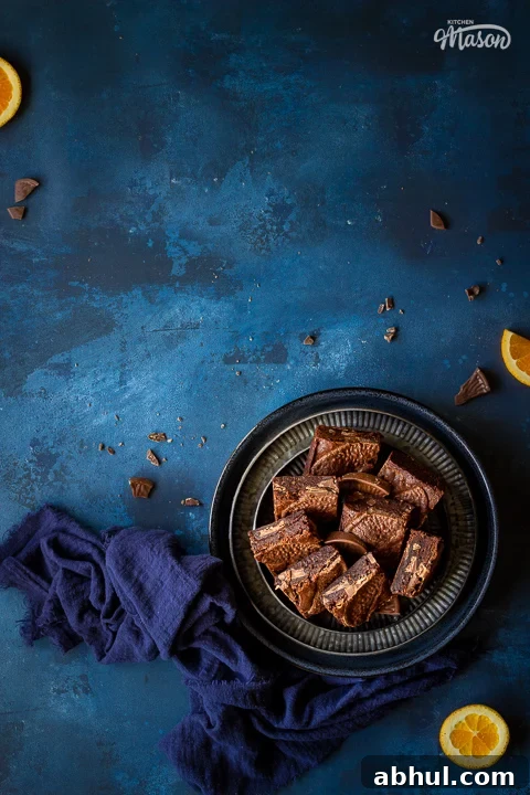 Chocolate orange brownies on a plate with orange slices
