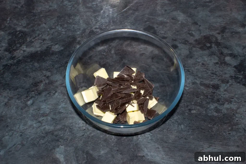 Broken chocolate and cubed butter in a glass bowl