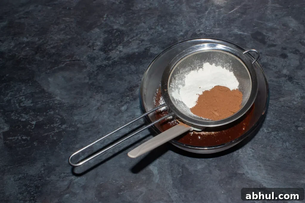 Flour and cocoa powder being added to brownie batter