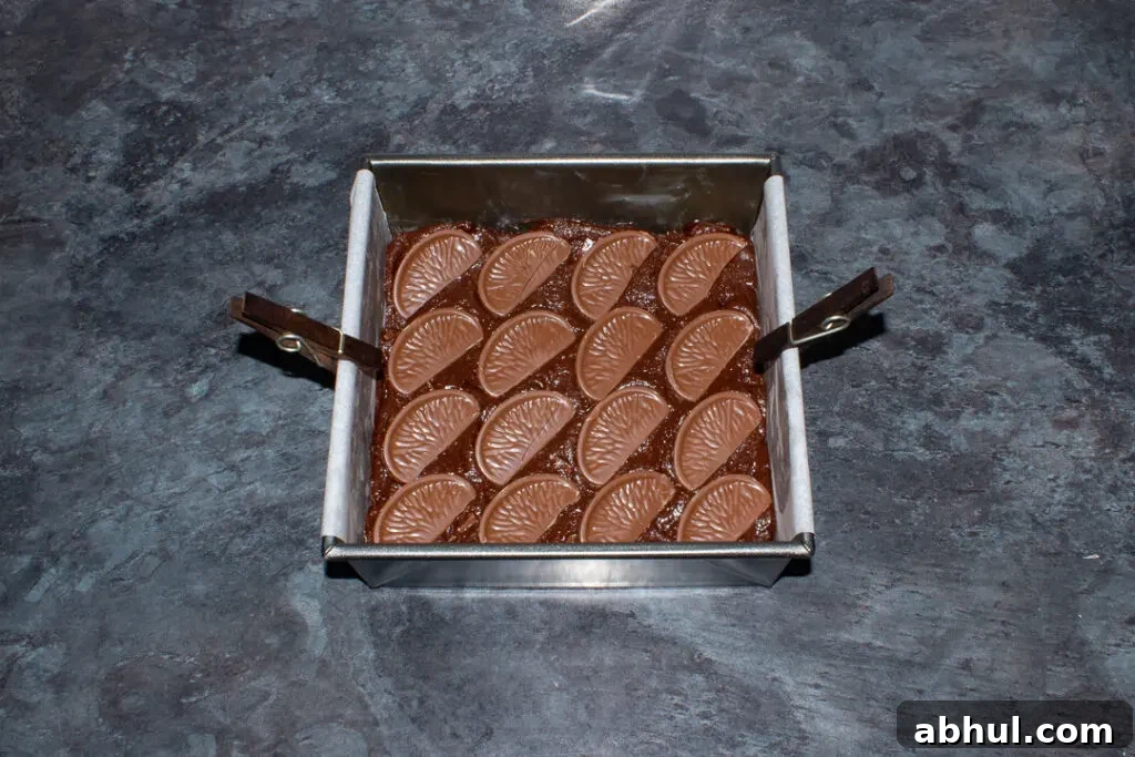 Terry's chocolate orange segments pressed into the top of brownie batter in a lined tin