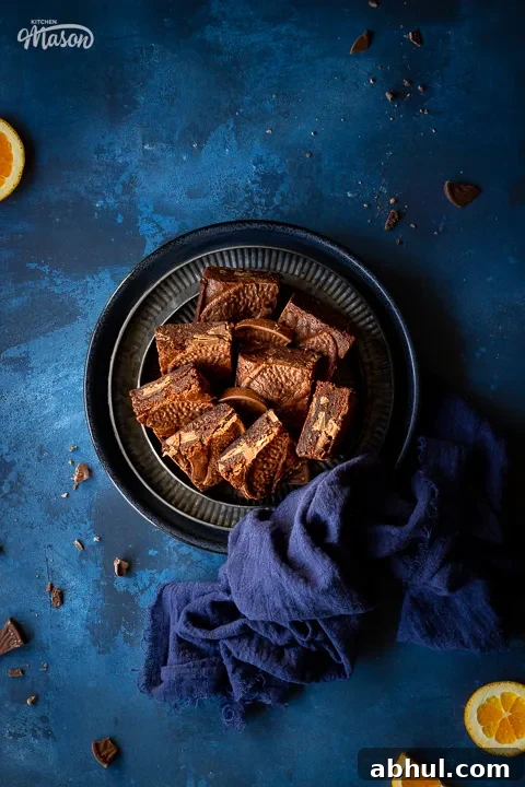 Terry's chocolate orange brownies on stacked plates with a blue napkin